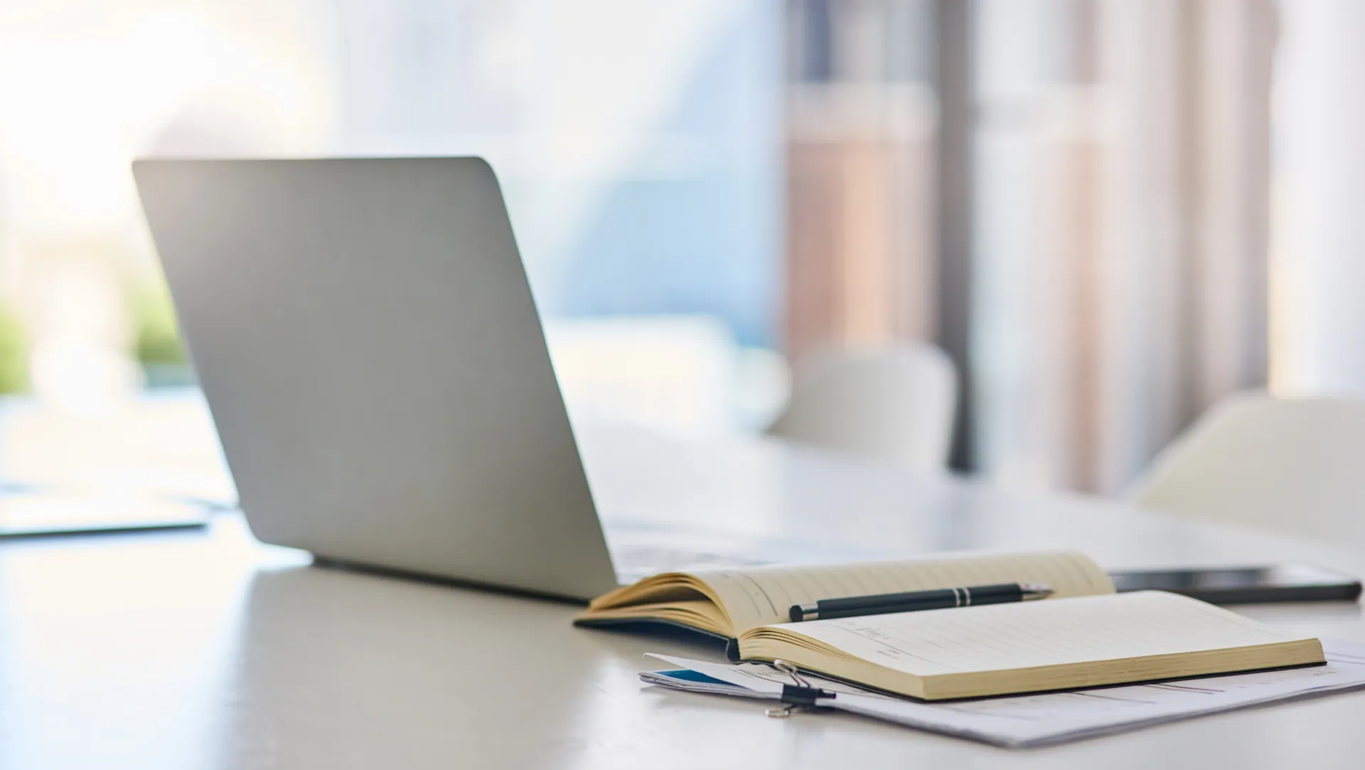 Scrivania con laptop e agenda per la psicoterapia online